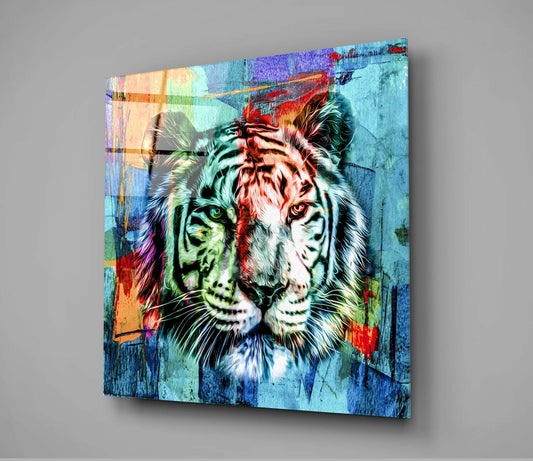 Angled view of a glass wall art panel displaying a colorful tiger face with split cyan, red, and green tones against a textured blue background.