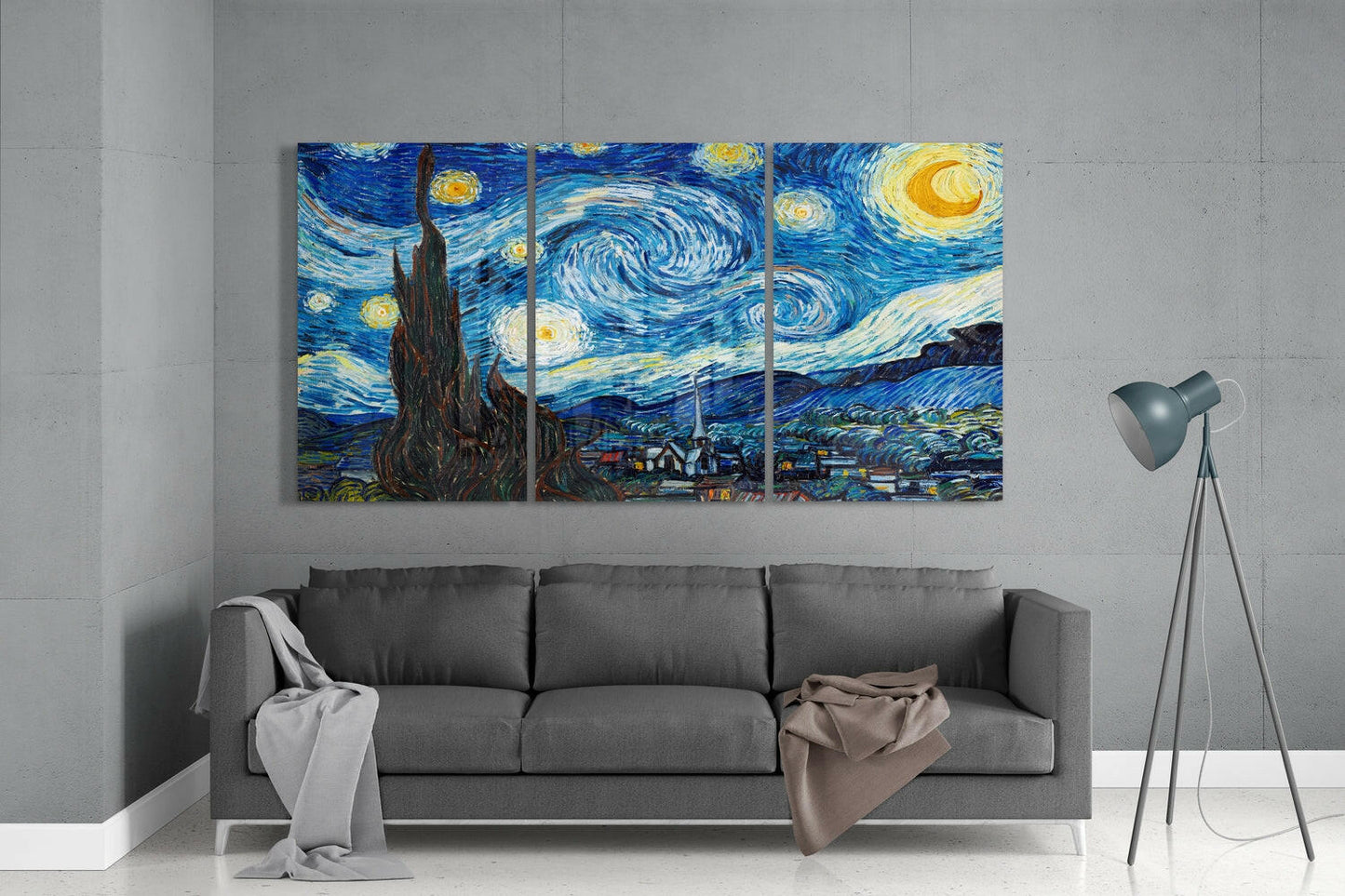 Three-panel glass wall art of Van Gogh's Starry Night hanging above gray sofa in minimalist interior space.