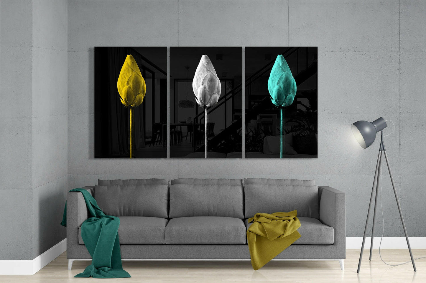 Three-panel glass wall art above gray sofa displaying yellow, white, and turquoise tulips on black backgrounds.