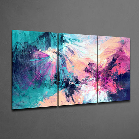 Three-panel turquoise, pink, and purple paint burst glass wall art displayed on gray wall at an angle.