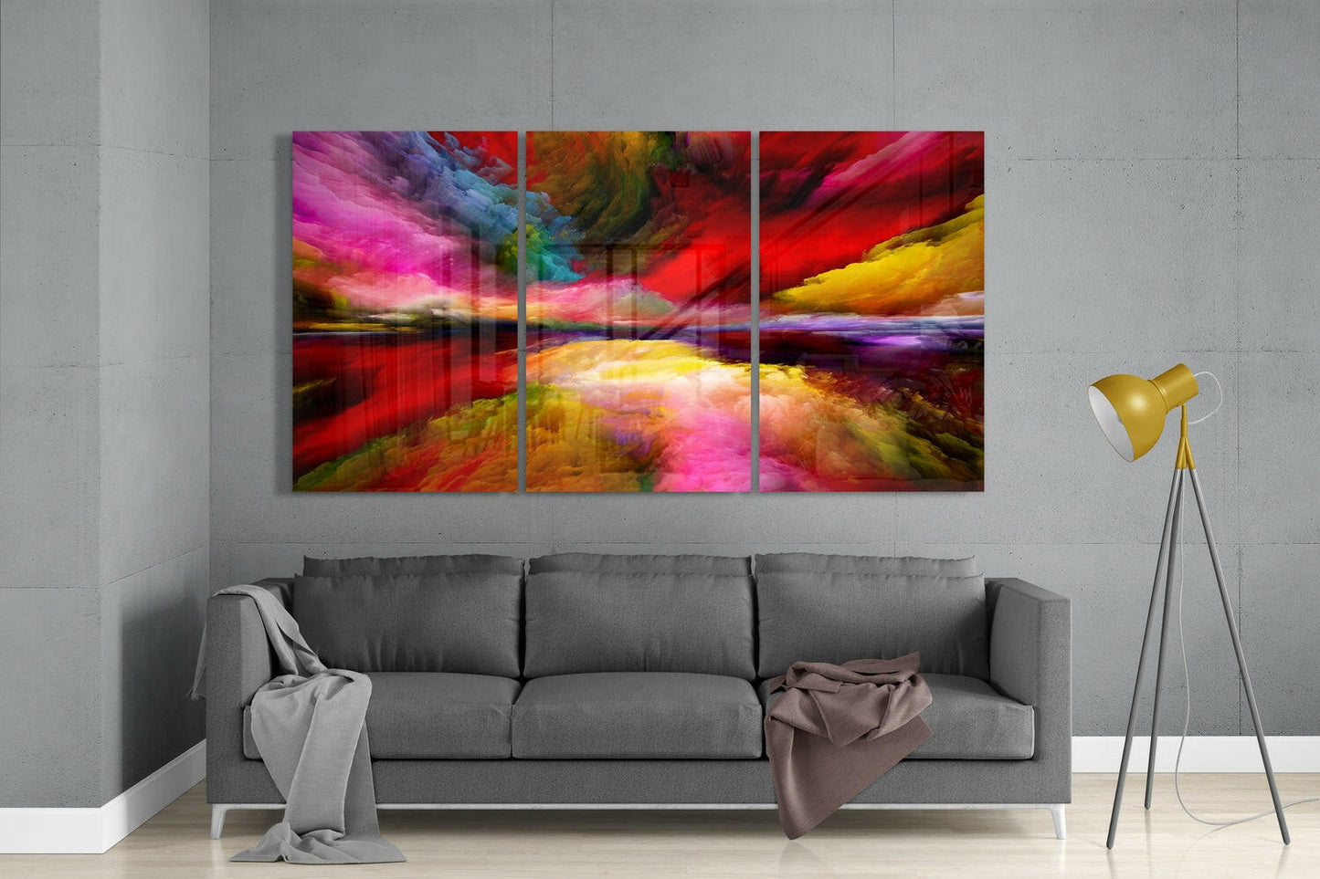 Vibrant multicolored abstract glass triptych mounted above gray sofa in modern living room setting.