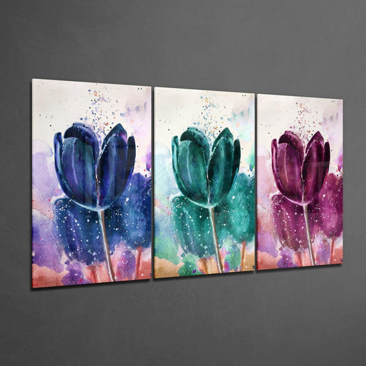 Three glass panels displaying watercolor tulips in blue, green, and magenta with colorful splashes, displayed at an angle against a gray wall.
