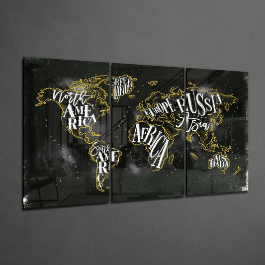 Three-panel black glass world map with gold continent outlines and white typography displaying regional labels, mounted on gray wall.
