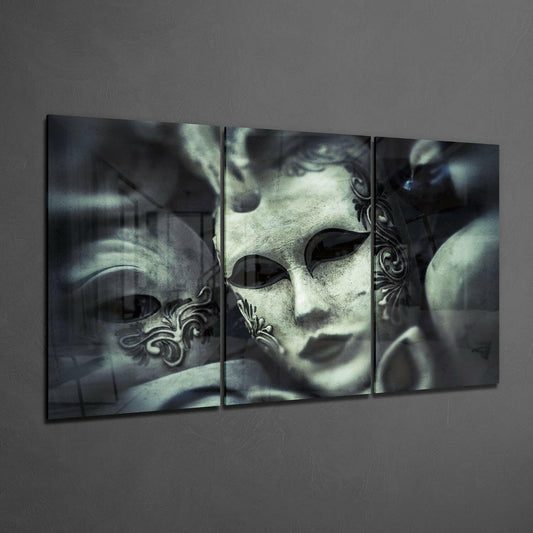 Three-panel glass wall art displaying ornate white Venetian masks with decorative details against a dark, moody background.