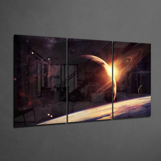 Three-panel glass wall art displaying a glowing planet with rings and bright sun against a starry cosmos, mounted on gray wall.
