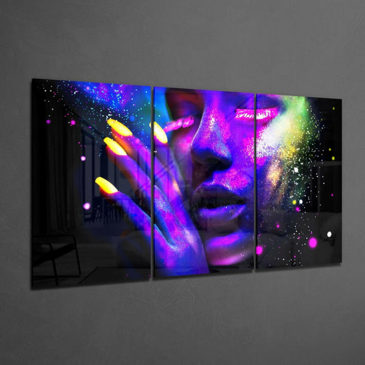Three-panel neon art glass display showing a woman's face and hand illuminated in vibrant blue, purple, pink, and yellow lights against black background.