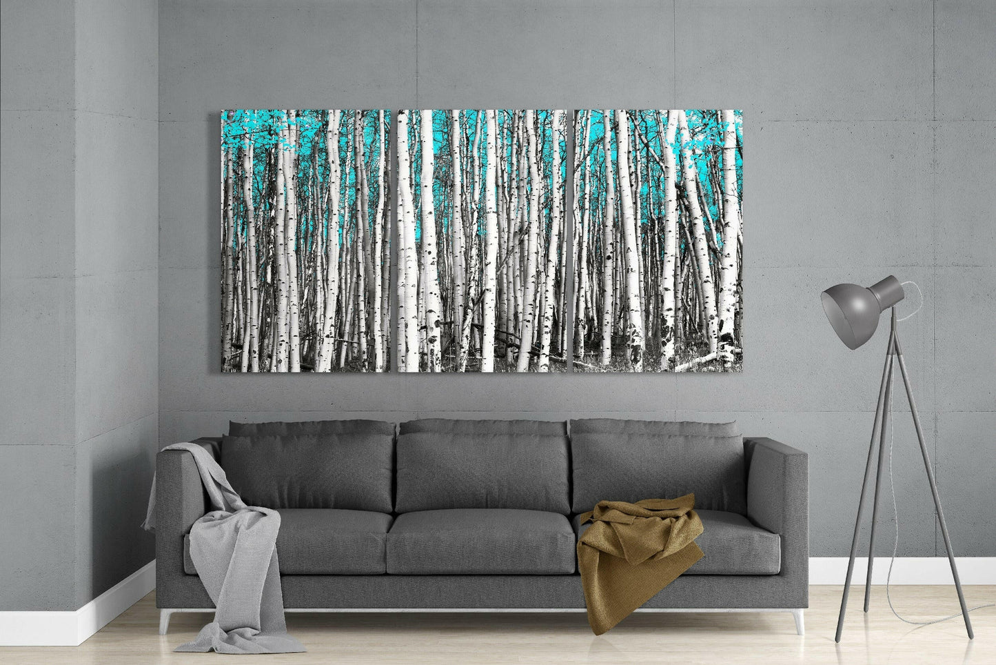 Turquoise and white birch forest glass art panel displayed above gray sofa in modern living room.