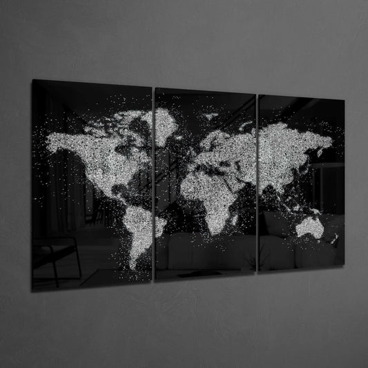 Three-panel black glass wall art displaying a world map rendered in white paint splatters against dark background.