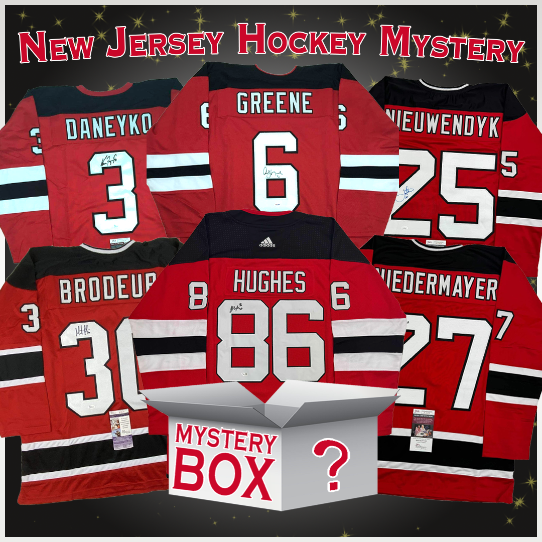 Six signed red New Jersey Devils jerseys displayed flat featuring players Daneuko, Greene, Nieuwendyk, Brodeup, Hughes, and Wiedermayer, with a mystery box centered below.