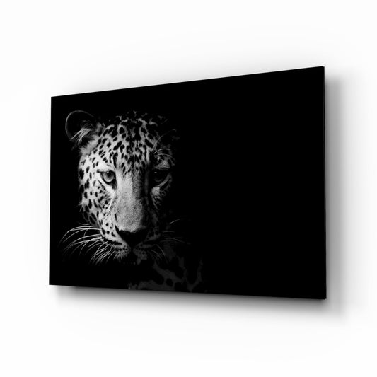 Black and white glass wall art displaying a leopard's face in profile against a dark background, mounted at an angle.