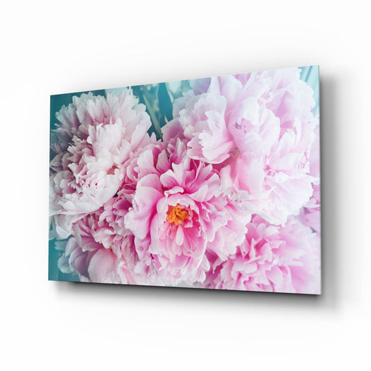 Angled perspective of glass wall art displaying pink and white peonies against teal background.
