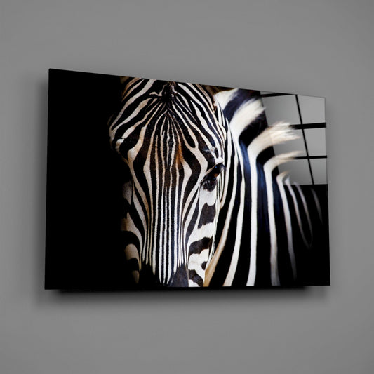 Glass wall art featuring a zebra head in profile with warm brown and black stripes against a dark background, displayed at an angle.