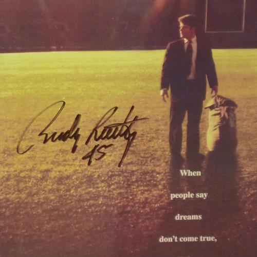 Signed movie poster showing man in suit standing on football field with handwritten autograph and inspirational text overlay.