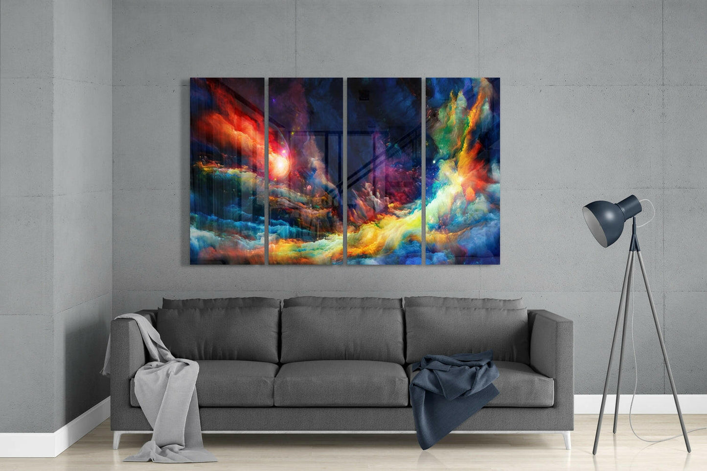 Four-panel glass wall art displaying swirling abstract clouds in vibrant reds, yellows, blues, and greens, hung above a gray sofa in a minimalist room.