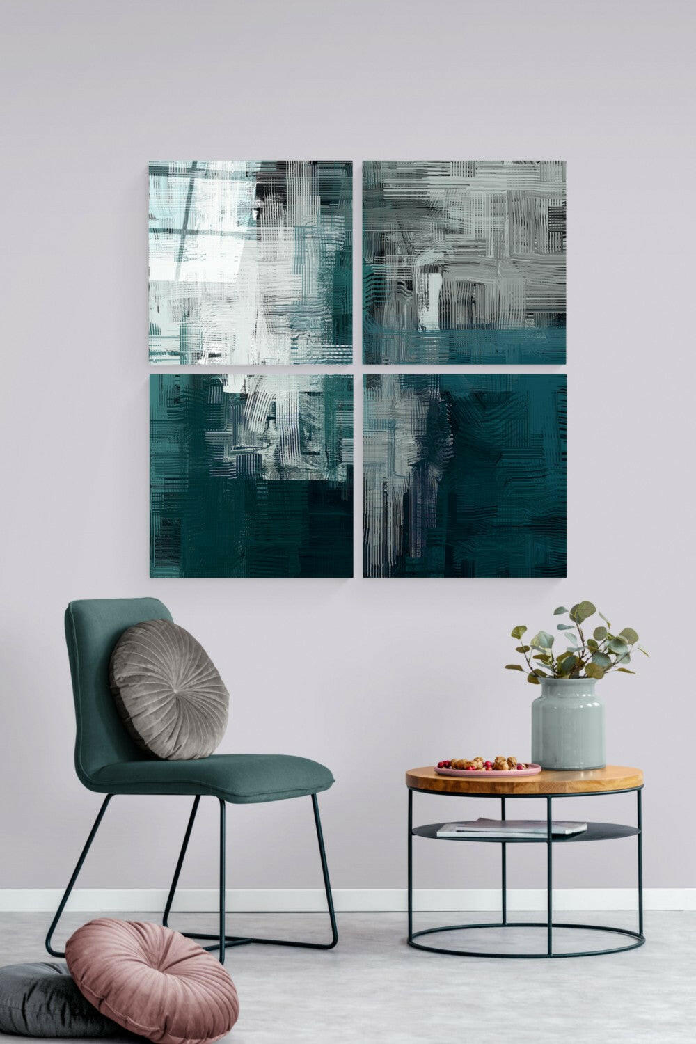 Four-panel teal and white abstract glass art displayed above a teal chair and wooden side table in a modern living room setting.