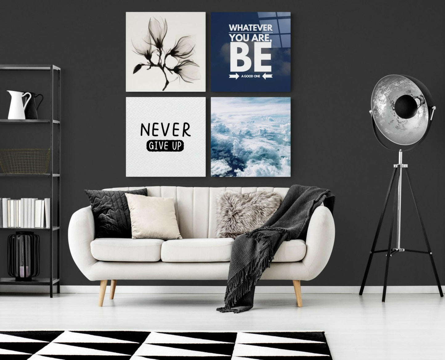 Four glass wall art panels in a grid arrangement above a white sofa, featuring floral, motivational, and sky photography designs in black, white, and blue tones.