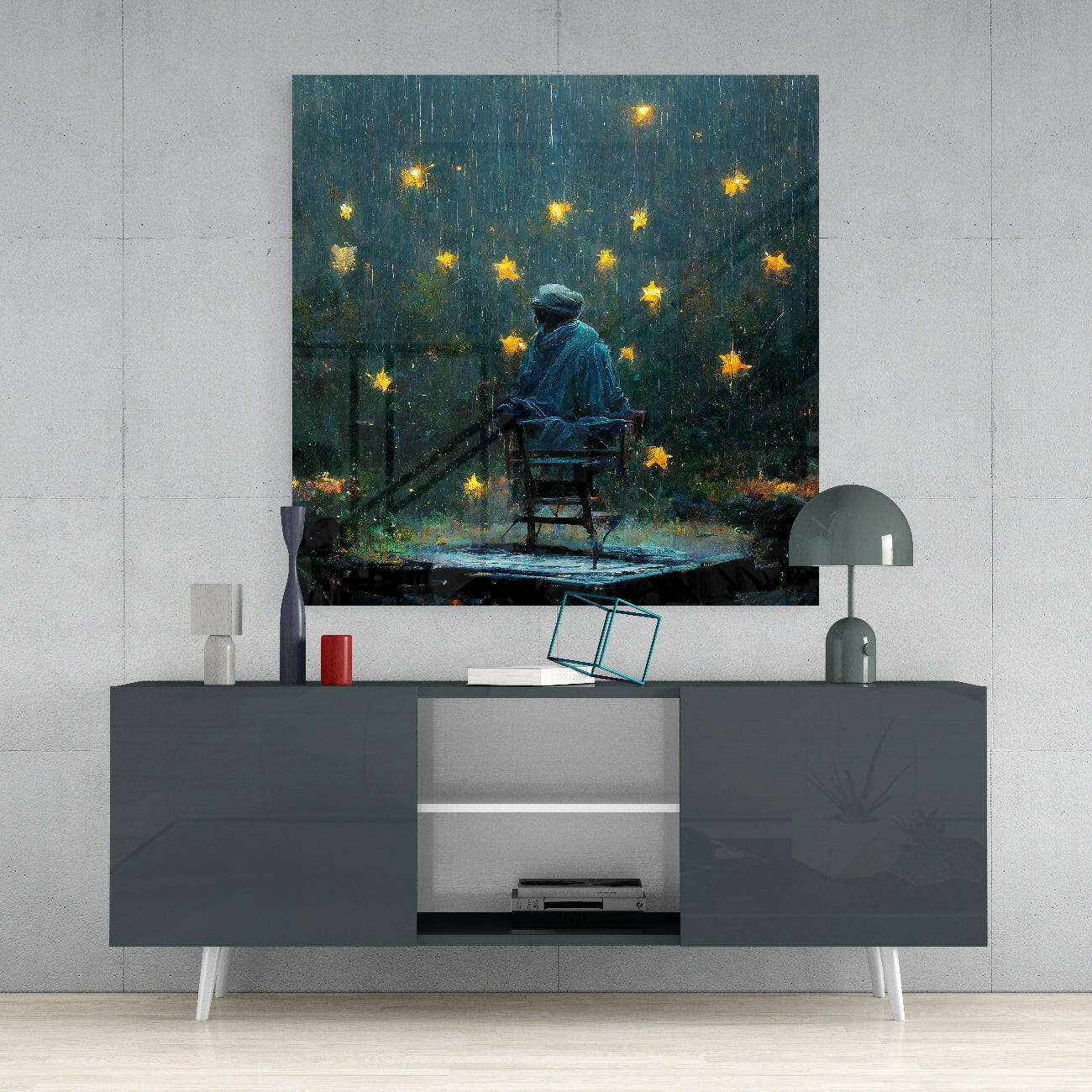 Glass wall art depicting a figure in blue jacket sitting on chair under falling golden stars in dark teal stormy setting, displayed above gray media console.