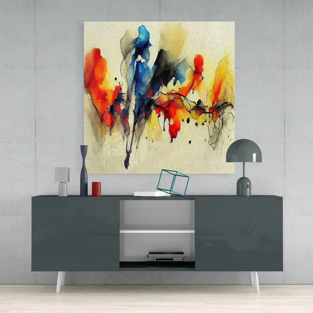 Abstract watercolor glass wall art in red, blue, yellow, and black displayed above a gray media console in a modern living room setting.