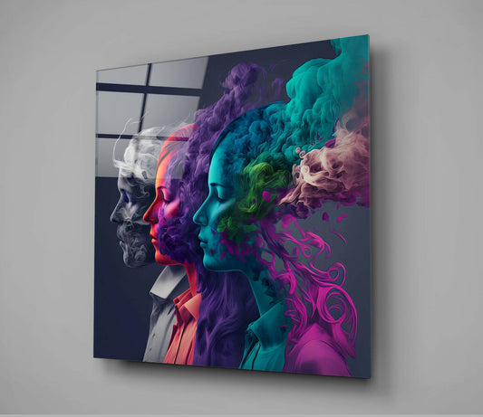 Glass wall art displaying four colorful profile heads in grayscale, red, purple, and cyan with flowing smoke effects against dark background.