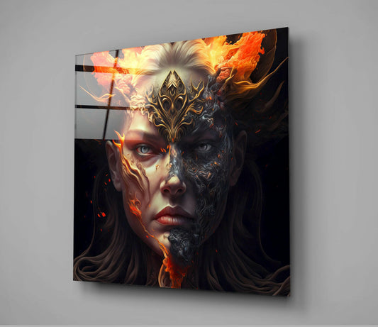 Glass wall art displaying a split-faced figure with fiery orange flames on one side and ornate golden mask details on the other, mounted on gray wall.