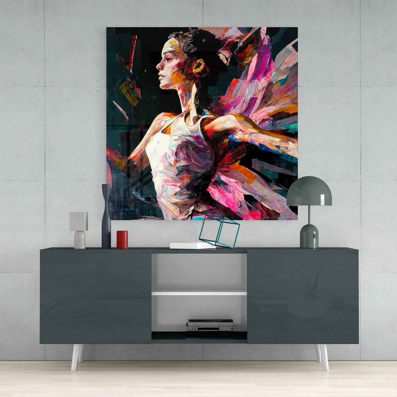 Vibrant abstract ballerina glass wall art displaying colorful brushstrokes in reds, pinks, and teals displayed above a dark console table.