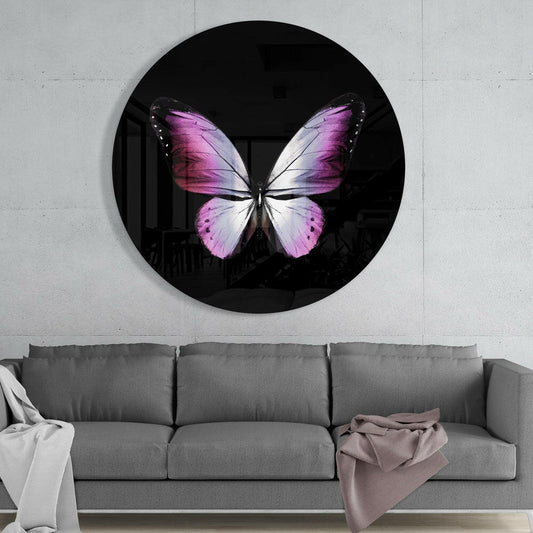 Round black glass wall art featuring a pink and white butterfly displayed above a gray sofa in a modern interior.