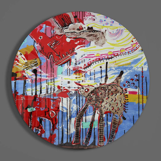 Circular glass wall art featuring a stylized brown giraffe with colorful abstract background in red, blue, yellow, and pink tones, photographed against gray backdrop.