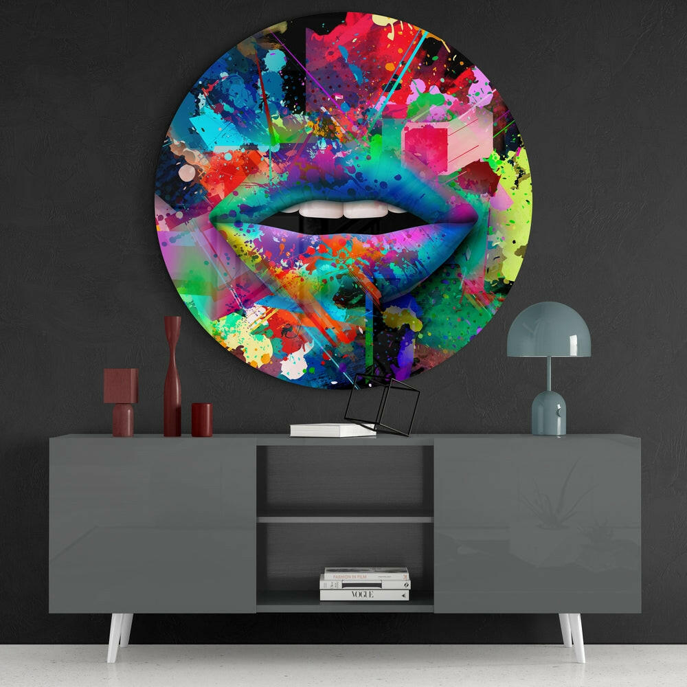 Colorful abstract lip glass wall art displayed above gray console table with decorative accessories and books.