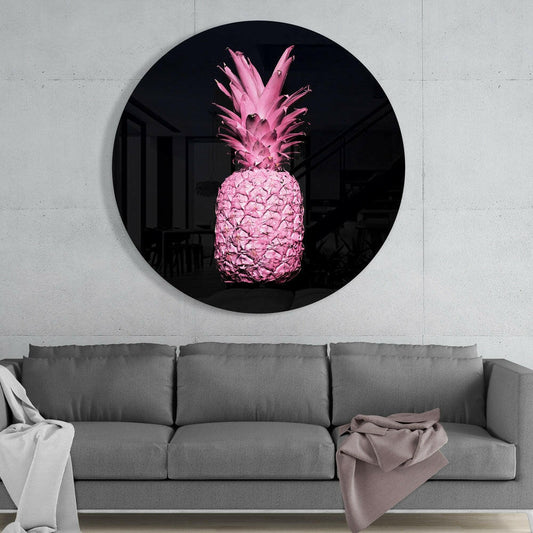 Round black mirror with glowing pink pineapple artwork mounted on white wall above gray sofa.