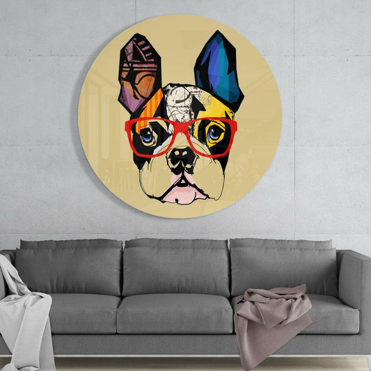 Circular yellow glass wall art featuring a colorful pop art bulldog wearing red glasses, displayed above a gray sofa in a modern interior.