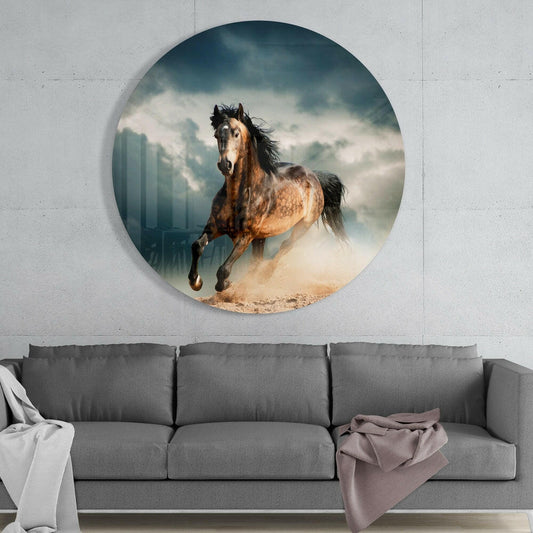Circular glass wall art mounted above gray sofa showing brown horse galloping in dust with stormy sky and architectural structures in background.