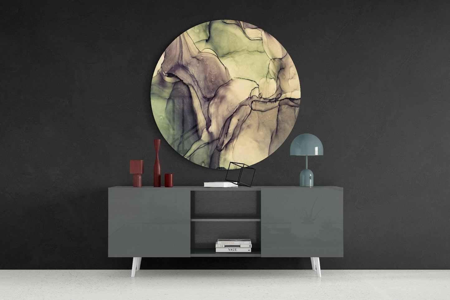 Round green and cream marble glass wall art displayed above a gray sideboard with red candles and blue lamp.