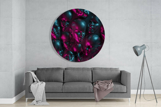Round glass wall art featuring neon pink and teal mannequin head sculptures mounted above gray sofa in minimalist interior.
