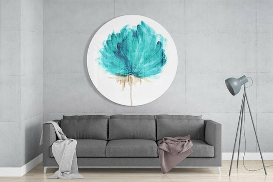 Circular glass wall art with teal watercolor flower and tan stem mounted above gray sofa in modern living room interior.