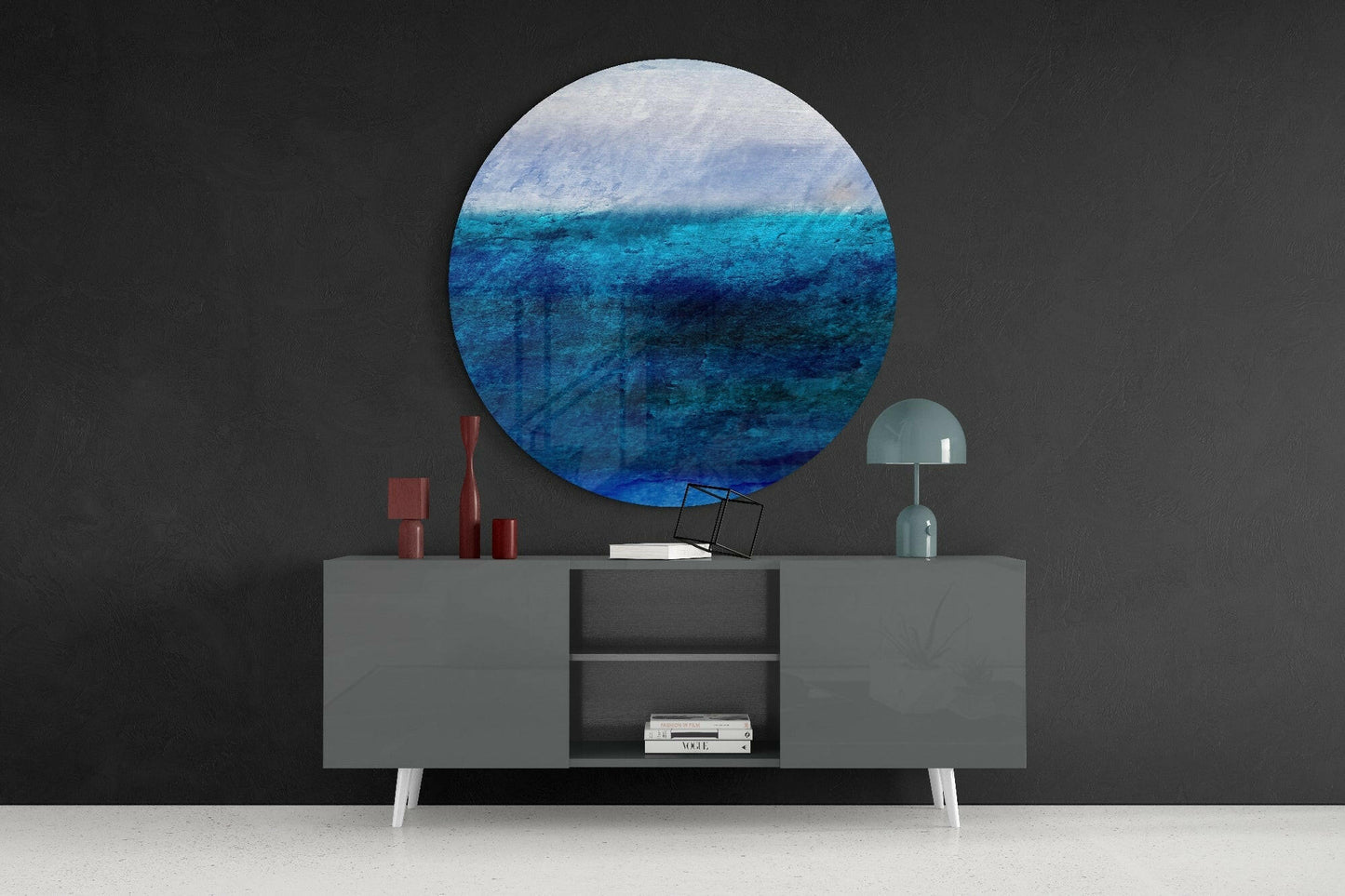 Blue Tones Glass Wall Art circular panel displaying ocean gradient from light sky to deep blue water, installed above gray sideboard with décor.