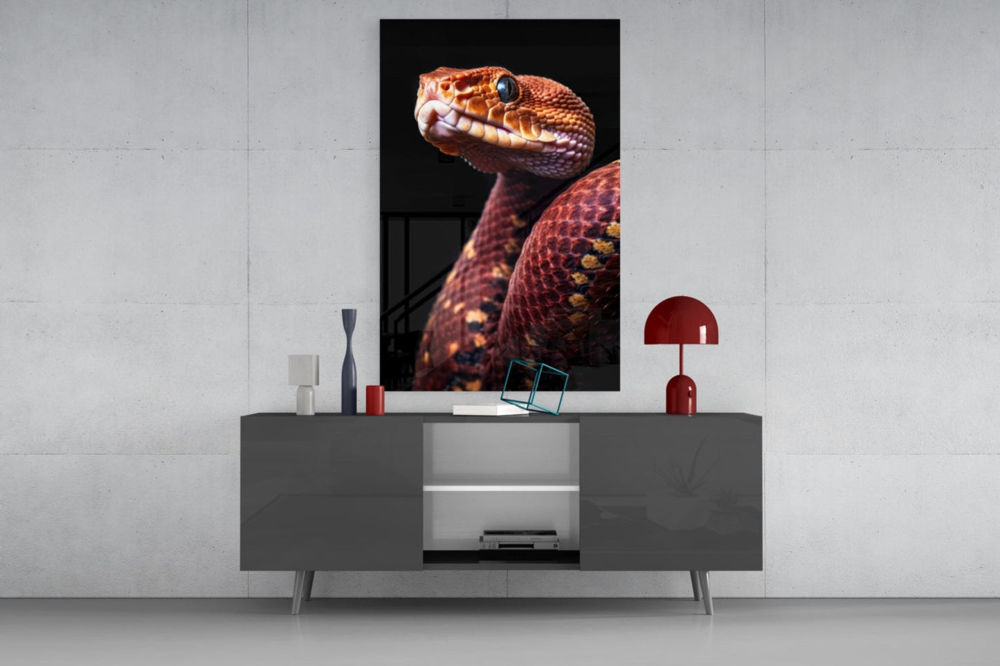 Red Garter Snake glass wall art displayed vertically above gray media console with decorative accessories and red lamp.