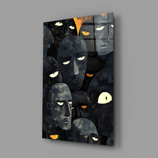 Black glass wall art panel displaying multiple stylized faces with glowing white and orange eyes against dark background, angled three-quarter view.