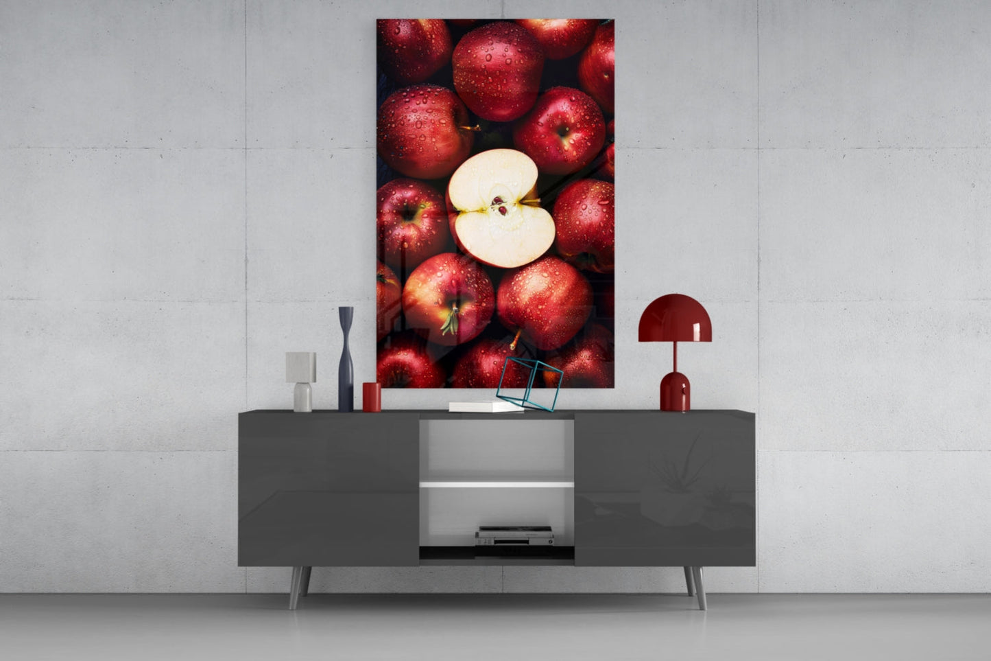 Modern living room display with "Queen of Apples" glass wall art mounted above gray media console with red apples and white apple slice imagery.