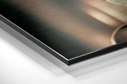 Close-up angled view of layered brushed aluminum and white composite materials showing edge detail and metallic surface texture.