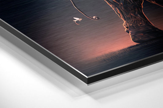 Angled edge-on view of brushed aluminum Dibond wall art showing layered construction with dark textured surface depicting an elephant profile and glowing amber sunset tones.