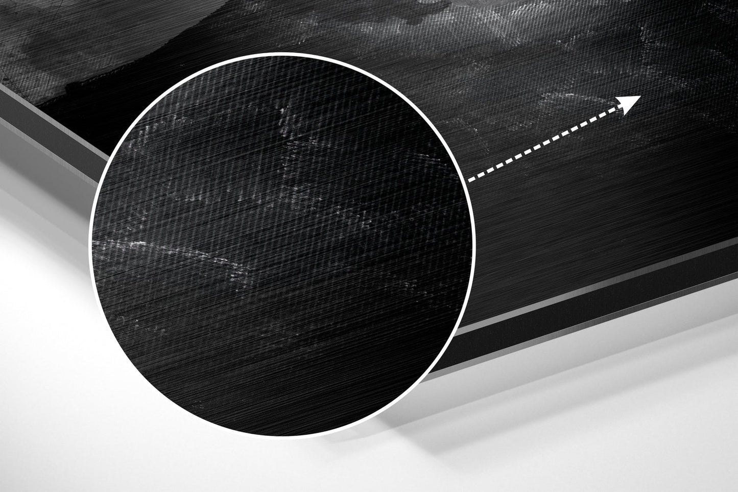 Close-up of brushed aluminum dibond wall art showing circular black textured design with white border and directional arrow on gray background.