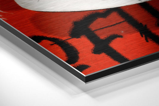 Angled close-up view of red and black checkerboard sneaker design on brushed aluminum wall art with white border.