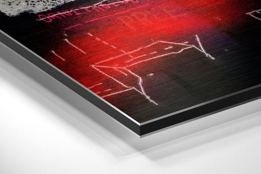 Angled view of red neon skull artwork on black brushed aluminum panel with white border, displayed on white surface.