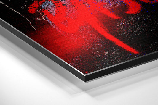 Angled view of layered aluminum dibond print showing red and black brushed metal surface with blue accents and gray mounting edges.