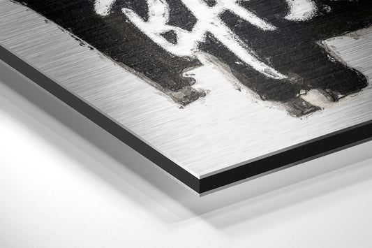 Close-up angled view of black and white crown design on brushed aluminum dibond panel with black border edge.