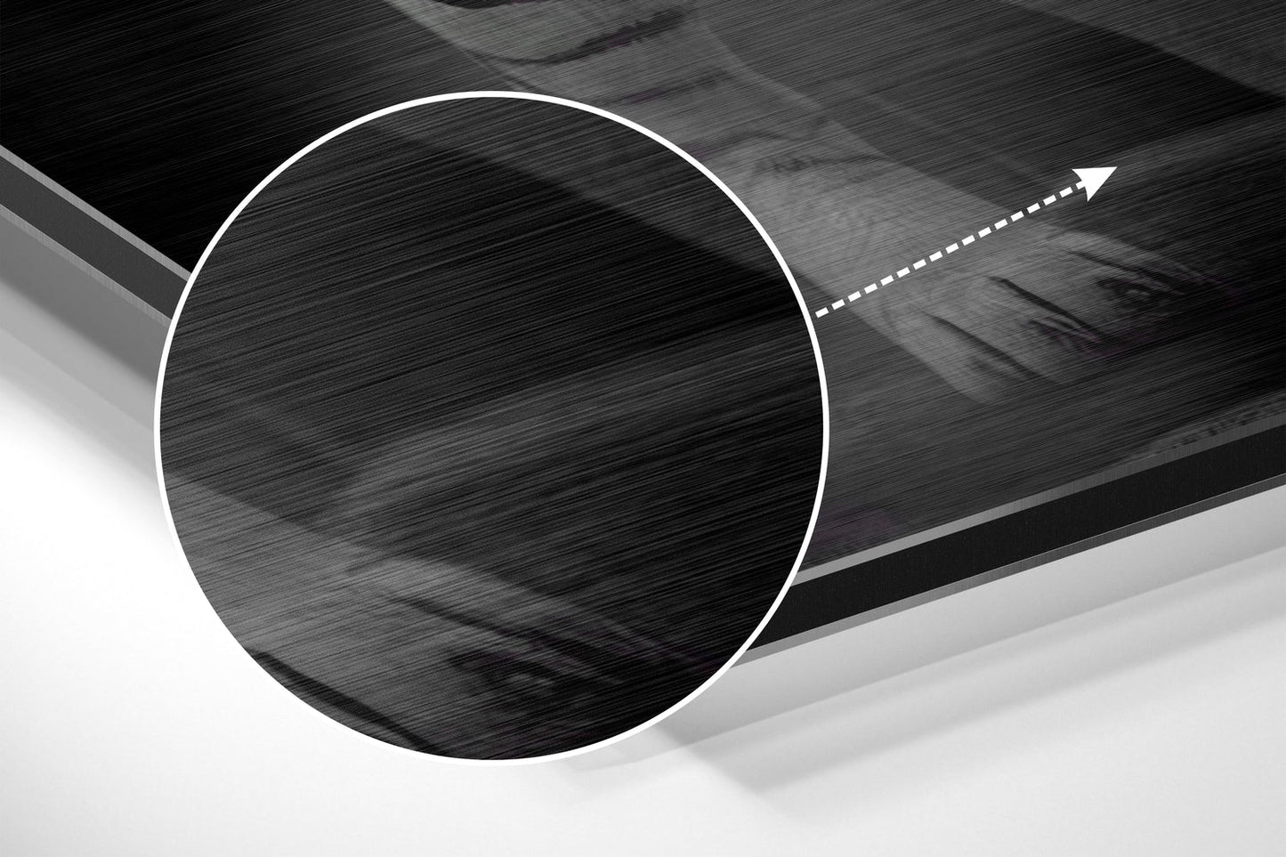Close-up detail of brushed aluminum surface with circular cutout and directional arrow indicator on dark abstract wall art.