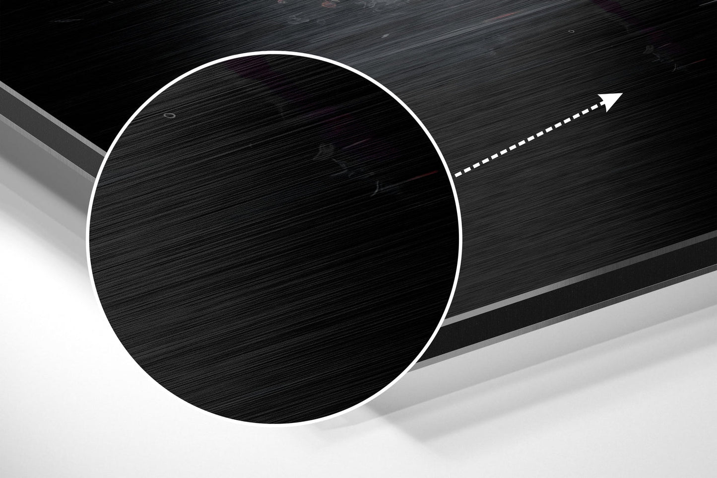 Close-up of circular brushed aluminum panel with white outline edge and directional arrow on dark textured background.