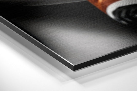 Close-up angled view of layered brushed aluminum and white composite materials showing edge detail and surface texture.