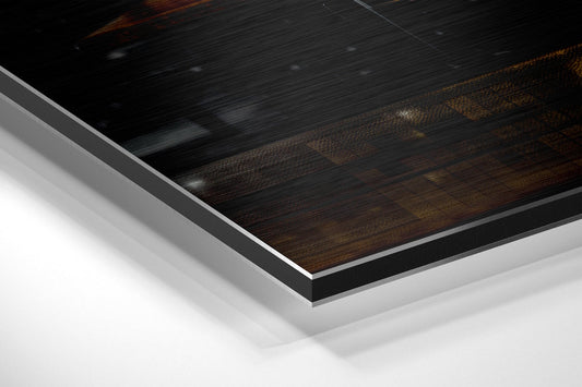 Close-up angled view of layered aluminum dibond print showing dark wood grain surface with silver metal edges and white base layer.