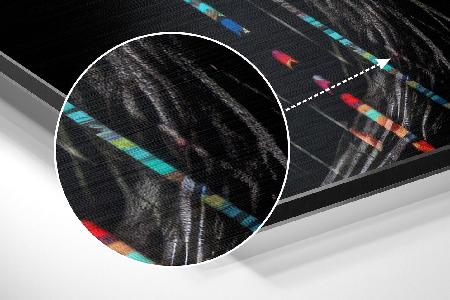 Close-up detail of brushed aluminum surface showing colorful horizontal stripes in cyan, red, orange, and yellow with black hair texture overlay.